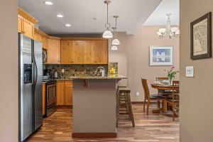 een keuken met een roestvrijstalen koelkast en een tafel bij Best Views of Canmore - 2Bed 2Bath in Canmore