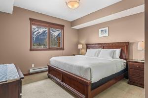 a bedroom with a bed and a window and a mountain at Best Views of Canmore - 2Bed 2Bath in Canmore