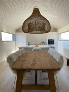 uma sala de jantar com uma mesa de madeira e um lustre em Polo Club Lodge em Lobos