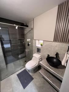 a bathroom with a toilet and a sink and a shower at Aerosuites in Bogotá