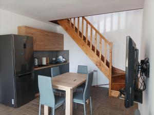 a kitchen with a wooden table and blue chairs at Lille Skandinavien 