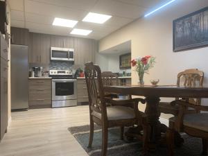 a kitchen with a wooden table with chairs and a dining room at Remo Ridge Bed N Breakfast in Terrace