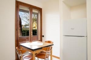 una cucina con tavolo, sedie e frigorifero di Casa Indipendente con Giardino a Cervia