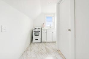 a white kitchen with a stove and a sink at NY Luxury 1BR PRIME location Free Parking! in Yonkers