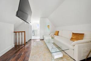 揚克斯的住宿－NY Luxury 1BR PRIME location Free Parking!，客厅配有白色沙发和玻璃桌