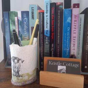 a book holder with pens and books on a shelf at Keistle Cottage in Eyre