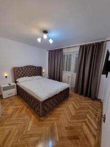 - une chambre avec un grand lit et du parquet dans l'établissement Lovely flat with hot tube Cornelia, à Corabia
