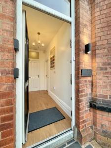 an open door to a hallway with a brick wall at Luxury 1 bed Apartment in Portadown