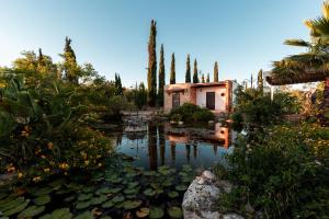 un giardino con laghetto e alberi e una casa di Uva Rosa a Gallipoli