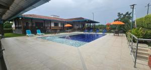 a swimming pool with chairs and umbrellas next to a house at PUENTE IGLESIA in Montenegro