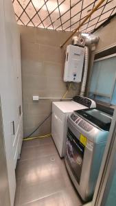 um pequeno quarto com uma máquina de lavar roupa em Hermoso departamento en norte de Quito em Quito