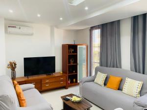 a living room with a couch and a flat screen tv at SuAparts in Praia