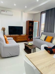 a living room with two couches and a flat screen tv at SuAparts in Praia