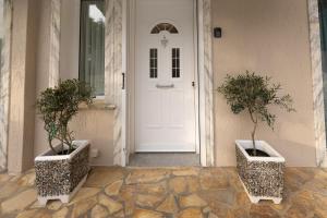 a white door with two potted trees in front of it at Villa Kataleya in Svoronata