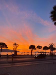 a sunset with a car parked on a street at Davide's guesthouse in Vlorë