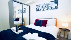 1 dormitorio con 1 cama grande y espejo en F3 Ground floor Luxury flat Gants Hill, en Redbridge