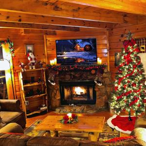 a living room with a christmas tree and a fireplace at CABIN in a GATED RESORT with SEASONAL RESORT POOL in Pigeon Forge