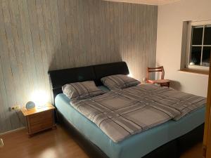 um quarto com uma cama grande e uma cabeceira preta em Ferienwohnung DOMiziel für 1 bis 4 Personen im Grünen em Hamm