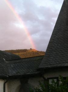 een regenboog in de lucht boven een huis bij FeWo-Rantafutt in Olsberg