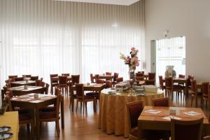 une salle à manger avec des tables, des chaises et des fleurs dans l'établissement Hotel Francis, à Beja