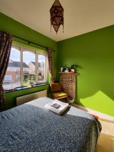 Dormitorio verde con cama y ventana en The Green Room Homestay, en Galway