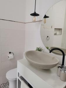 uma casa de banho com um lavatório, um WC e um espelho. em Dzixile em Gueima