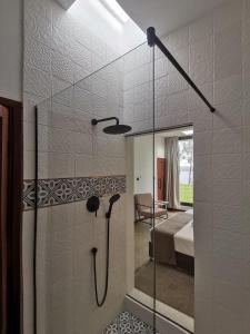 a bathroom with a glass shower with a bed at Dzixile in Gueima