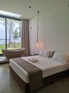 a bedroom with a large bed and a large window at Dzixile in Gueima