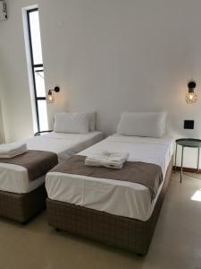two twin beds in a room with two windows at Dzixile in Gueima