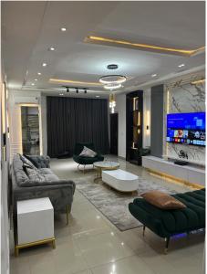 a living room with couches and a flat screen tv at Luxurious 2 bedroom Apartment with Private Chef in Lagos