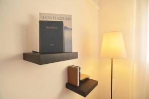 una stanza con una lampada e un libro su un muro di Casa della Magnolia - In pieno Centro Storico a Padova