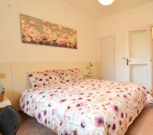 a bedroom with a bed with a floral comforter at Casa della Magnolia - In pieno Centro Storico in Padova