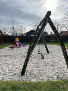 a swing set in the sand in a playground at Private Rooms in center of Billund in Billund