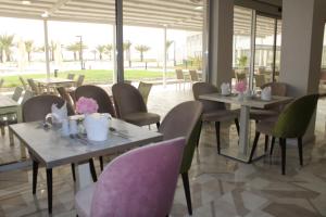 un restaurante con mesas y sillas con flores. en Gadileh Resort Hotel, en Yibuti