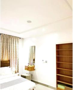 a white bedroom with two beds and a window at Luxurious 2 bedroom Apartment with Private Chef in Lagos