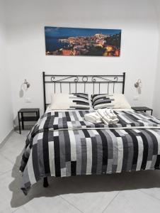 ガエータにあるB&B Il Geranioのベッド(黒と白のストライプの掛け布団、枕付)