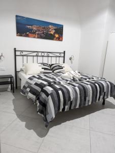 ガエータにあるB&B Il Geranioの白と黒のベッドルームのベッド