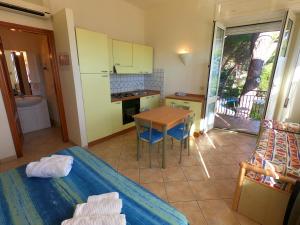 a room with a kitchen and a table with a tableablish at Villa Emilia appartments in Cala Gonone