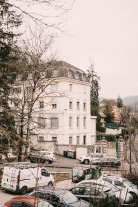 a large white building with cars parked in a parking lot at Ultimate Comfort ! Jacuzzi & Sauna. in Besançon
