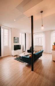 a living room with a couch and a television at Ultimate Comfort ! Jacuzzi & Sauna. in Besançon