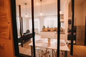 a kitchen and living room with a table and chairs at Ultimate Comfort ! Jacuzzi & Sauna. in Besançon