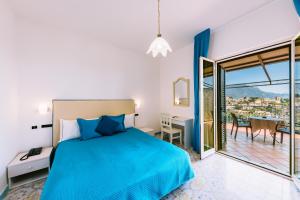 a bedroom with a blue bed and a balcony at Hotel Villa Giuseppina in Scala