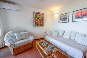 a living room with a couch and a chair at Marinella-Porto Rotondo, Accesso Diretto sulla SPIAGGIA in Porto Rotondo