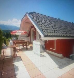 una casa con una mesa y un banco en un patio en Faakersee Seahouse mit Privat Strand -Only Sa-Sa en Faak am See