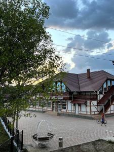 un gran edificio con un parque infantil delante de él en Pensiunea Ancuței, en Şerpeni