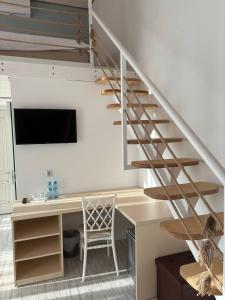 a room with a desk and a spiral staircase at Pensiunea Ancuței in Şerpeni +12 photos