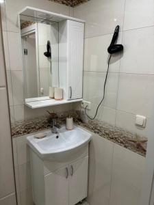 La salle de bains est pourvue d'un lavabo et d'un téléphone mural. dans l'établissement Pensiunea Ancuței, à Şerpeni