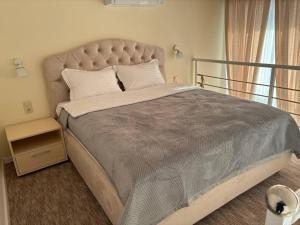 a bedroom with a large bed with a large headboard at Pensiunea Ancuței in Şerpeni