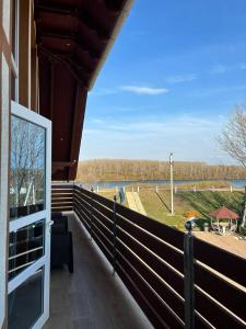 a balcony of a house with a view of a river at Pensiunea Ancuței in Şerpeni