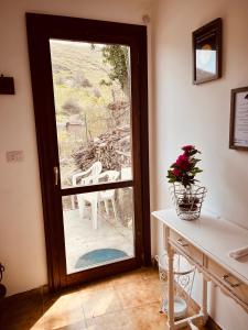 a door leading to a patio with a table and flowers at La Mansarda di Terelle in Terelle